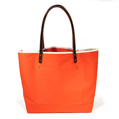 Flame orange waxed canvas tote with brown leather handles
