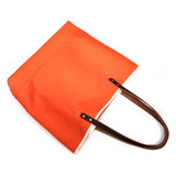 Flame orange waxed canvas tote with brown leather handles