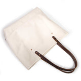 Neutral off-white tote in natural canvas with brown leather straps
