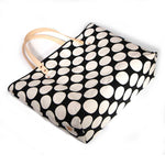 Bold white and black oversized dot print tote with blonde leather handles and canvas trim