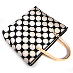 Bold white and black oversized dot print tote with blonde leather handles and canvas trim