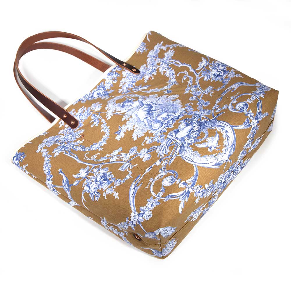 tote with oak and ink blue toile print with brown leather handles and natural canvas body