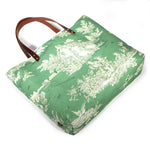 Emerald green toile print canvas tote with natural canvas top and brown leather handles