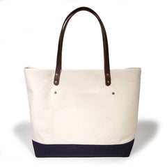 Natural canvas tote with navy bottom and brown leather handles