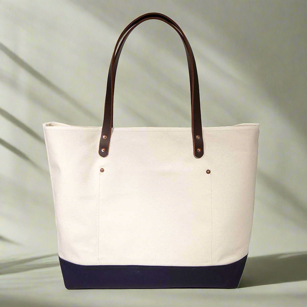 Lifestyle Natural canvas tote with navy bottom and brown leather handles