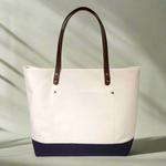 Lifestyle Natural canvas tote with navy bottom and brown leather handles