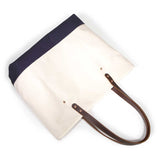 Natural canvas tote with navy bottom and brown leather handles