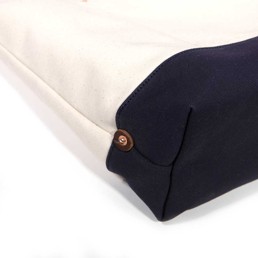 Detail Natural canvas tote with navy bottom and brown leather handles