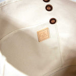 Interior Natural canvas tote with orange bottom and dark brown leather handles