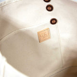 Interior Natural canvas tote with orange bottom and dark brown leather handles