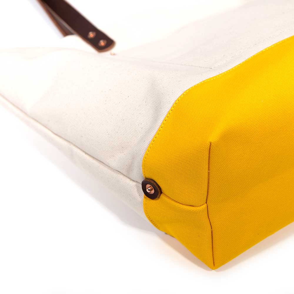 Detail Natural canvas tote with yellow bottom and brown leather handles