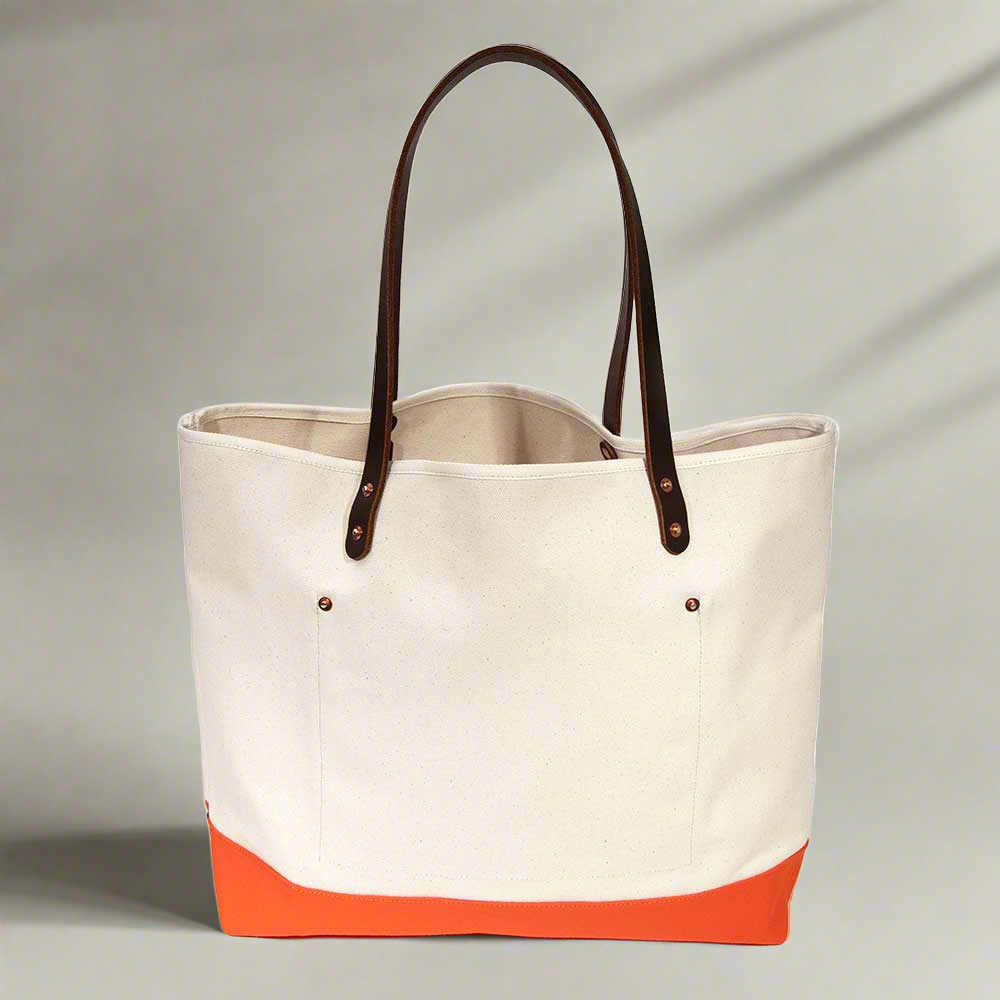 Lifestyle Natural canvas tote with orange bottom and dark brown leather handles