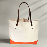 Lifestyle Natural canvas tote with orange bottom and dark brown leather handles