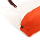 Detail Natural canvas tote with orange bottom and dark brown leather handles