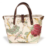 Front of the Botanique Floral Print Mini Tote, a deep rose bloom and sage foliage on golden branches, with mahogany handles and button tab