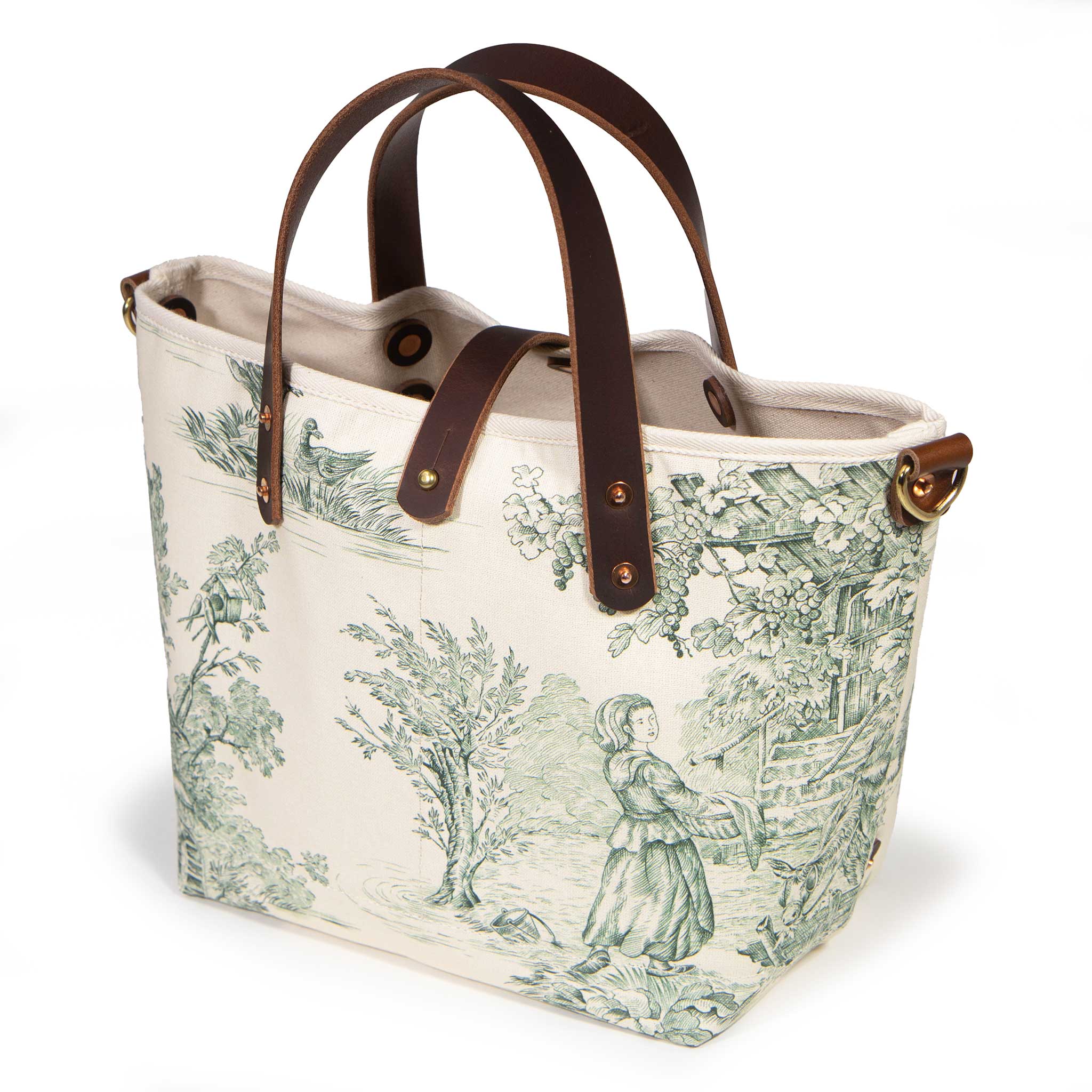 Butter and Pine Toile Mini Tote, three-quarter view, pine green toile on cream with mahogany leather handles and a brass D-ring