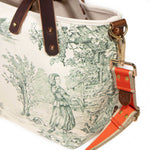 Close-up of the orange striped strap clipped to the brass D-ring of the Butter and Pine Toile Mini Tote