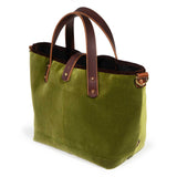 Luxe Velvet Mini Tote in peridot green, three-quarter view, with brown velvet binding, mahogany leather handles and a brass D-ring