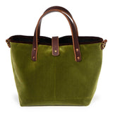 Front of the peridot green Luxe Velvet Mini Tote, with mahogany leather handles, copper rivets and a button tab