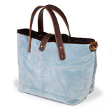 Luxe Velvet Mini Tote in glacier blue, three-quarter view, with brown velvet binding, mahogany leather handles and a brass D-ring