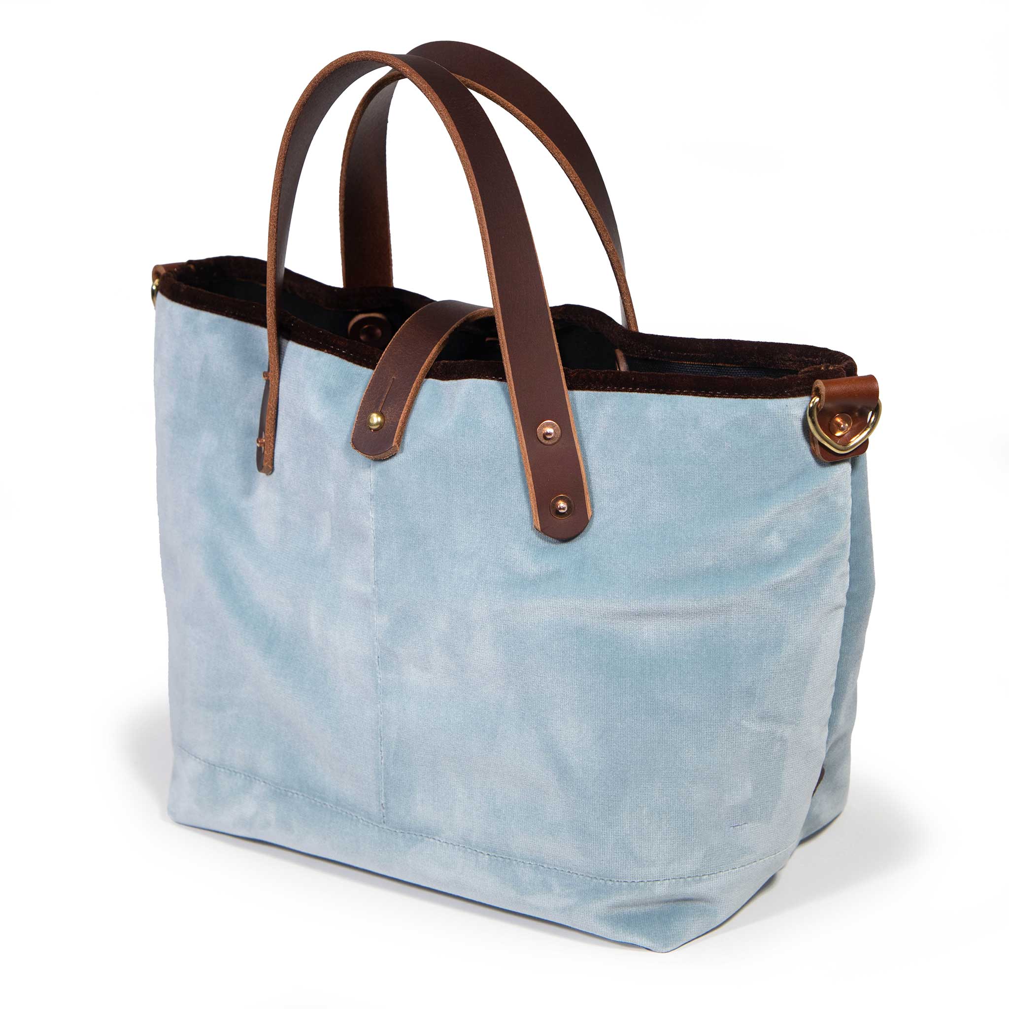 Luxe Velvet Mini Tote in glacier blue, three-quarter view, with brown velvet binding, mahogany leather handles and a brass D-ring