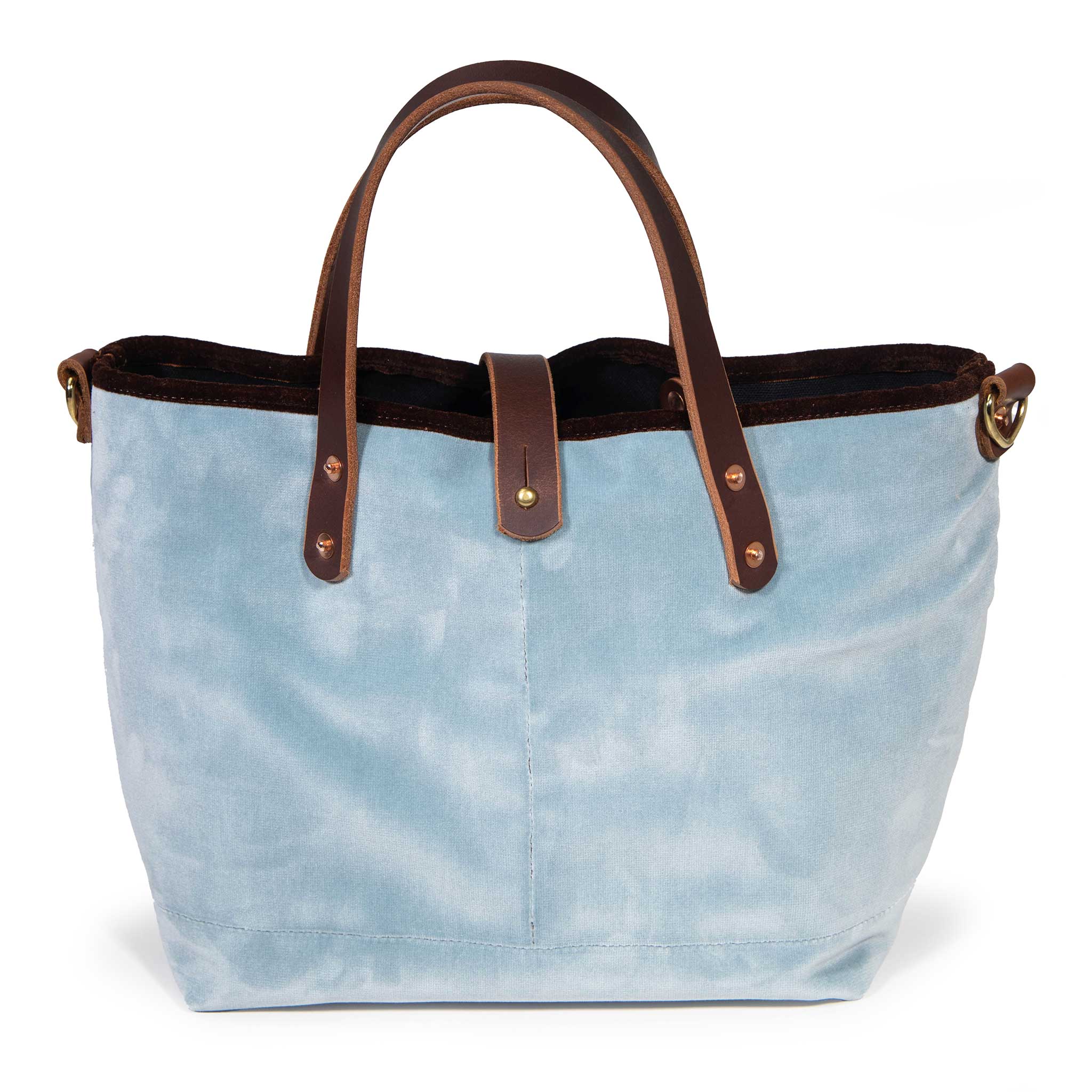 Front of the glacier blue Luxe Velvet Mini Tote, with mahogany leather handles, copper rivets and a button tab