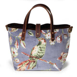 Aviary Luxe Velvet Mini Tote, front view: a green songbird on a blossoming branch, hand-printed on dove grey cotton velvet, with mahogany leather handles and a brass button closure