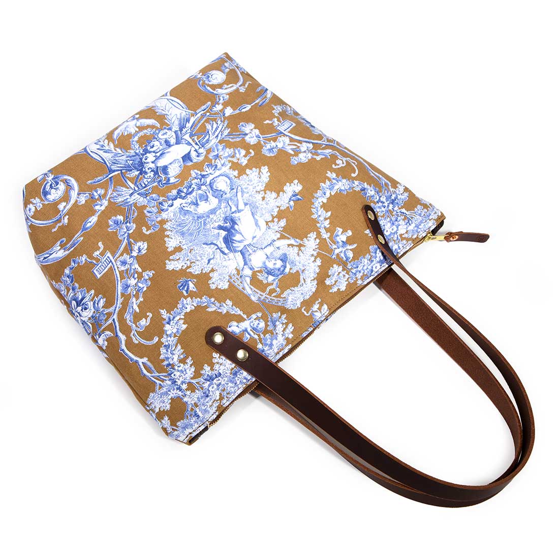 Portfolio tote featuring oak and ink blue toile print with brown leather handles and zipper