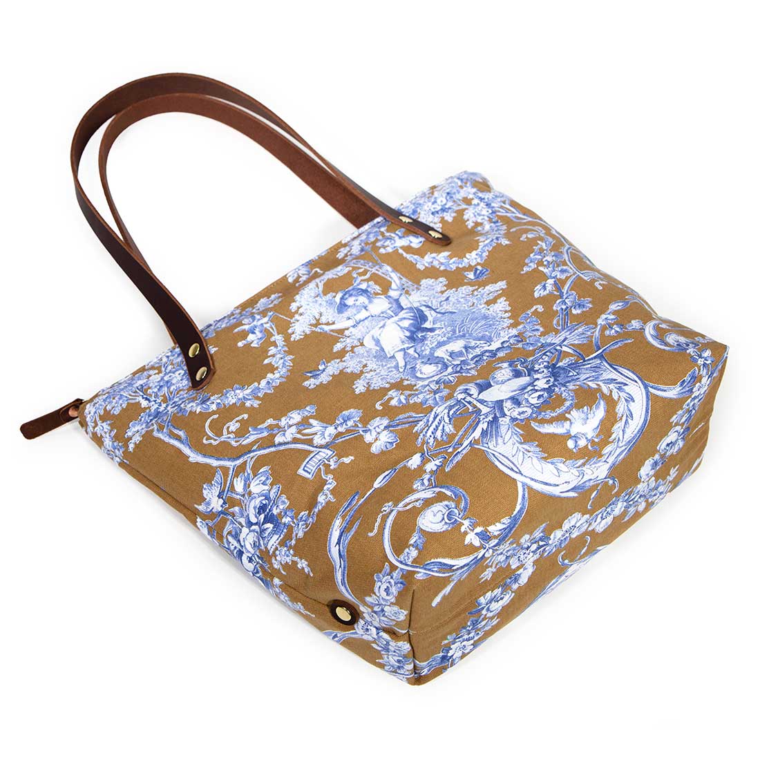 Portfolio tote featuring oak and ink blue toile print with brown leather handles and zipper