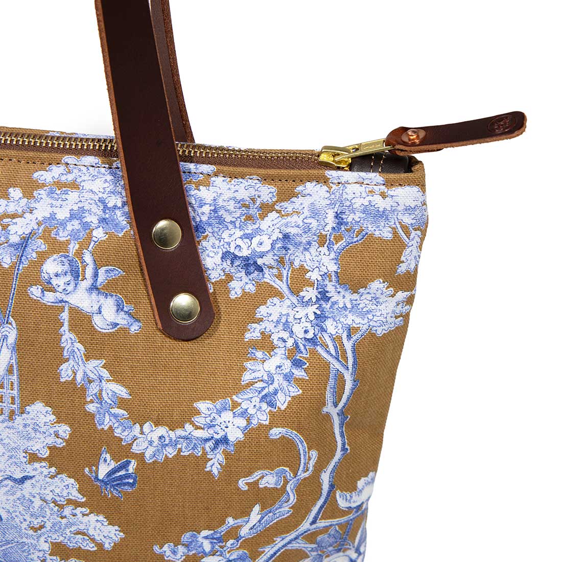 Detail Portfolio tote featuring oak and ink blue toile print with brown leather handles and zipper