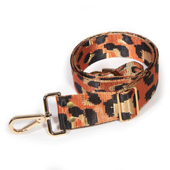 Orange leopard jacquard purse strap, black spots and metallic gold on a rust orange ground