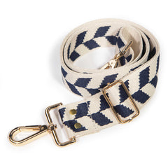 Detail of the navy and cream chevron purse strap showing the brass clip and slide adjuster
