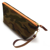 The Ranger Camouflage Travel Clutch, olive and brown camouflage, shown with its detachable mahogany leather wristlet clipped to a brass D-ring