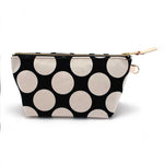 Front of the Monster Dot Travel Clutch, oversized cream dots on black, with brass zipper and blonde leather pull