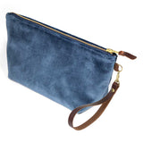The Wedgewood Blue Velvet Travel Clutch, Wedgewood blue velvet, shown with its detachable mahogany leather wristlet clipped to a brass D-ring