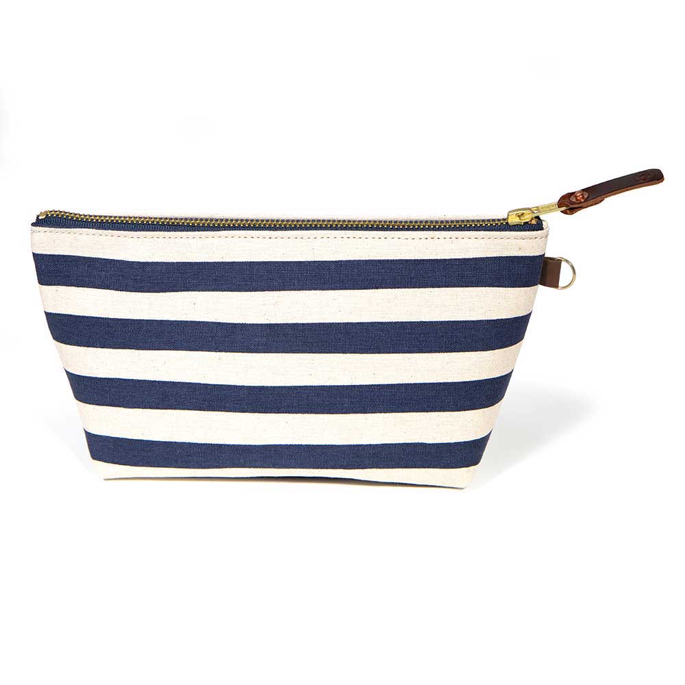 Front of the Navy Cabana Stripe Travel Clutch, wide navy and white stripes, with brass zipper and mahogany leather pull