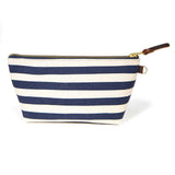 Front of the Navy Cabana Stripe Travel Clutch, wide navy and white stripes, with brass zipper and mahogany leather pull