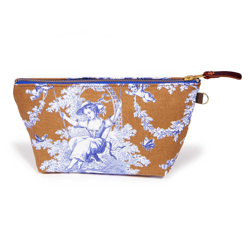 Front of the Oak and Ink Toile Travel Clutch, blue toile scenes on oak brown, with brass zipper and mahogany leather pull
