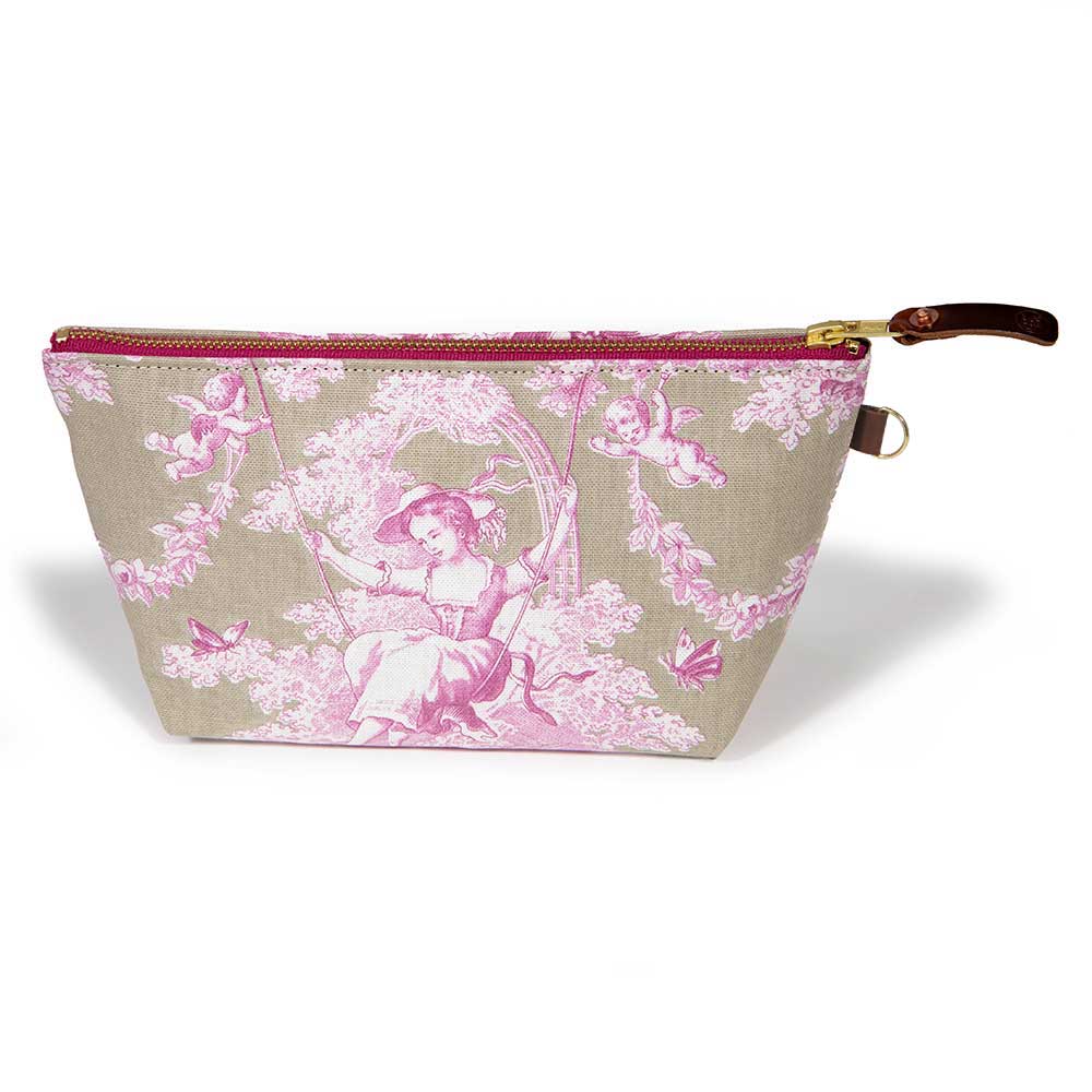 Front of the Sand and Rose Toile Travel Clutch, rose-pink toile scenes on sand, with brass zipper and mahogany leather pull