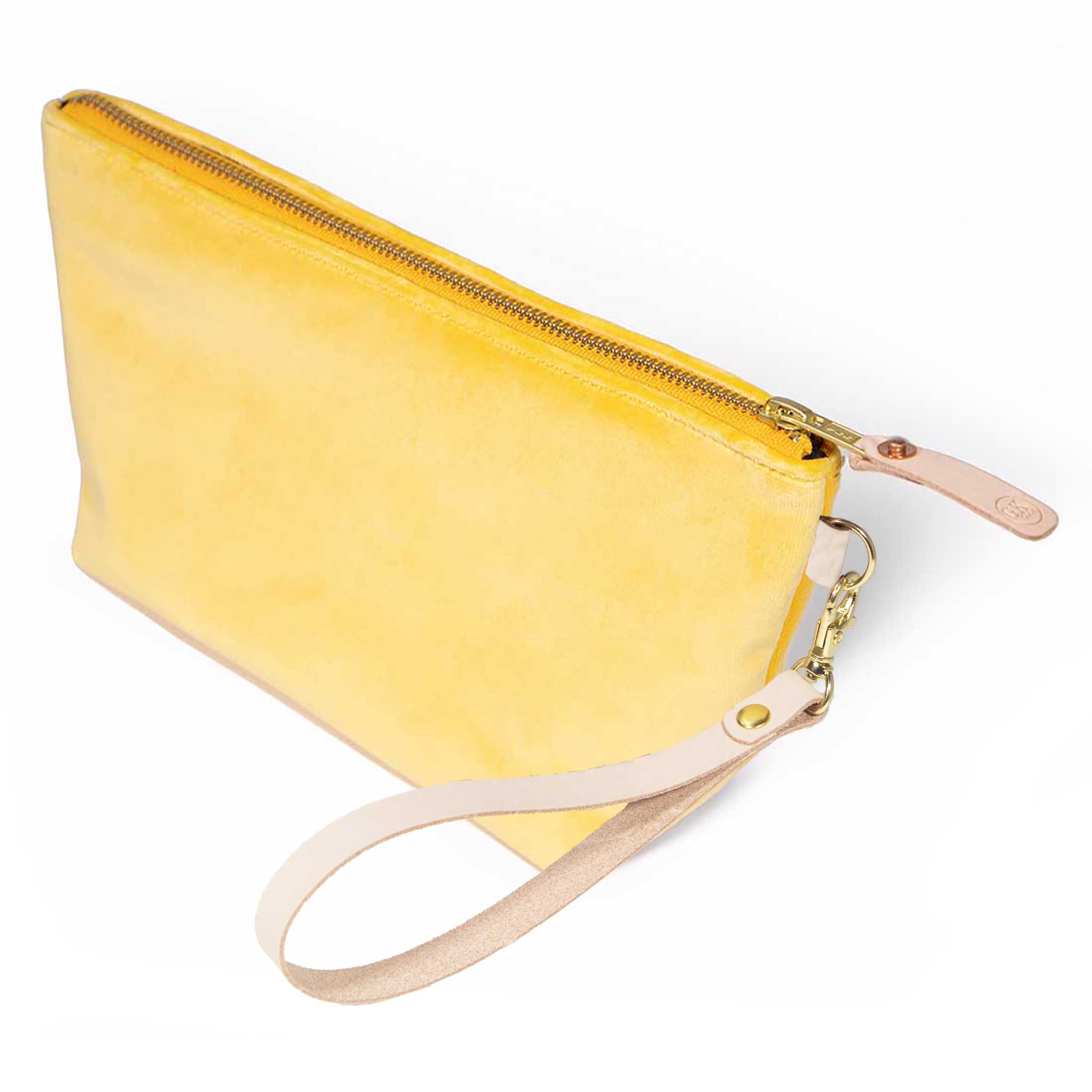 The Sunshine Velvet Travel Clutch, sunshine yellow velvet, shown with its detachable blonde leather wristlet clipped to a brass D-ring