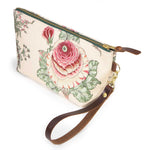 Botanique Floral Print Travel Clutch with its detachable leather wristlet clipped to a brass D-ring, showing a pink cabbage rose on a cream ground