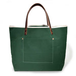 Dark green waxed canvas tote bag with contrast stitching and brown leather handles