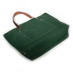 Dark green waxed canvas tote bag with contrast stitching and brown leather handles