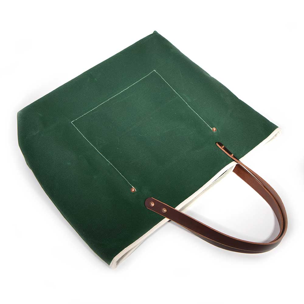 Dark green waxed canvas tote bag with contrast stitching and brown leather handles