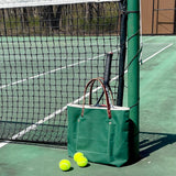 Lifestyle Dark green waxed canvas tote bag with contrast stitching and brown leather handles